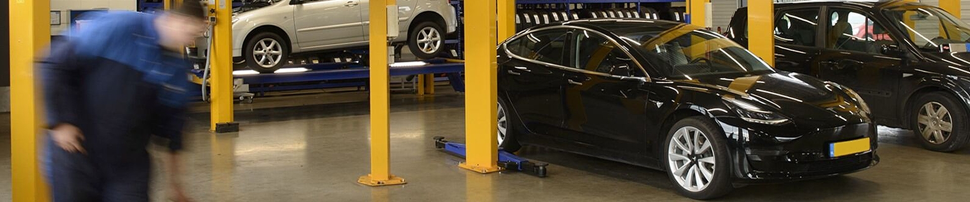 KwikFit monteur met elektrische auto's voor EV onderhoudsbeurt